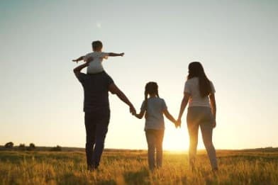 Family silhouetted against sunset
